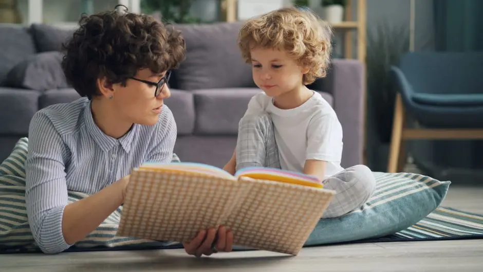 Balita membaca buku bersama ibu di rumah